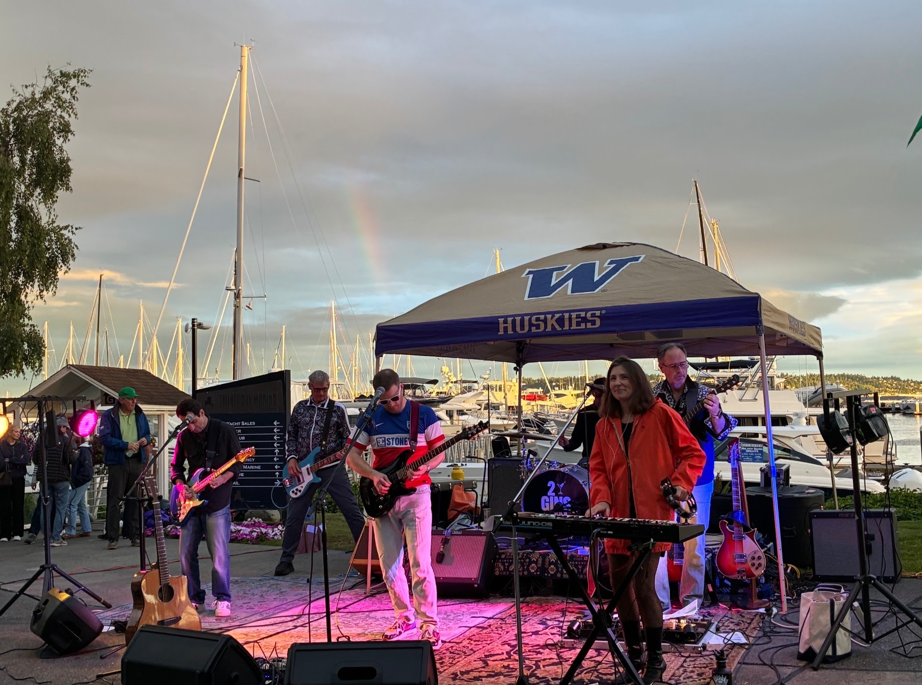 Band performing at Elliott Bay Marina with a rainbow over the sailboats
